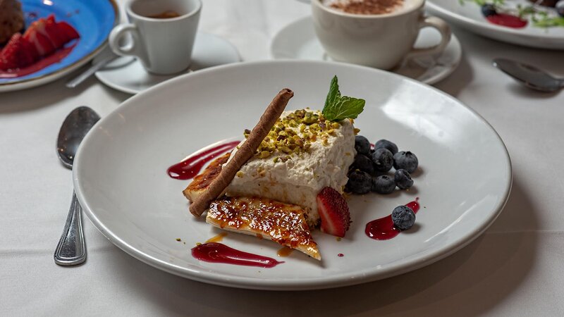 Baklava dessert topped with berrys and crumbled nuts