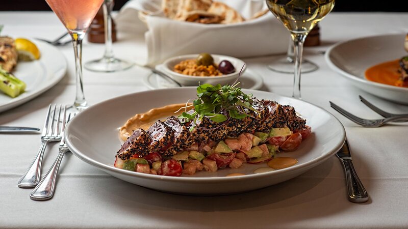 Crusted seafood on a bed of vegetables topped with sprouts